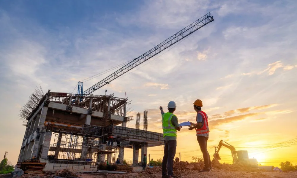 Tradies and builders looking at a construction site while discussing how to minimise cost