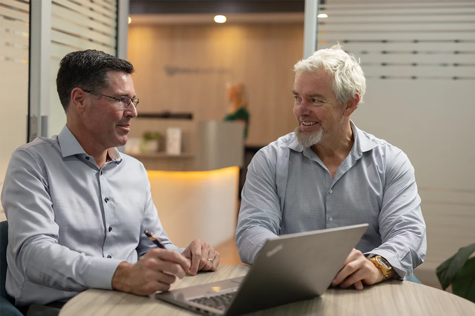 Professional Accountants having discussion over a laptop