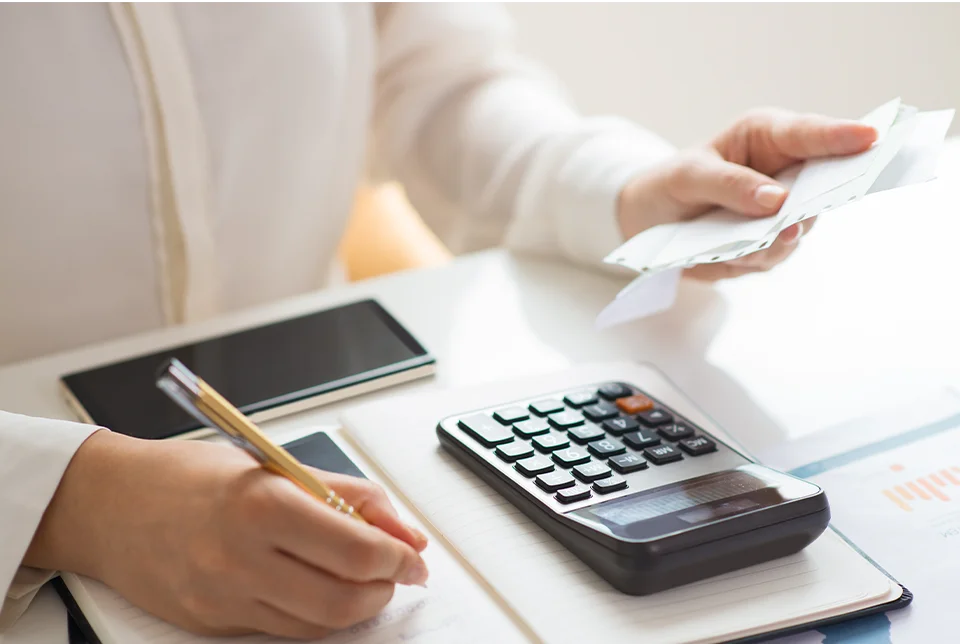 Xero Specialist Bookkeeper using a calculator and taking notes of the receipt